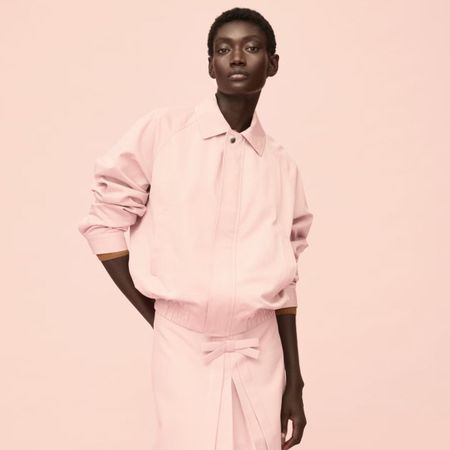 Woman wears pink jacket, pink skirt 