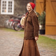a woman wears a brown suede jacket