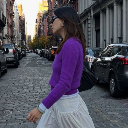Influencer @vivianyrl wears a purple knit with a white skirt and red socks.