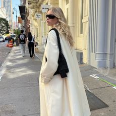 Elsa Hosk wearing a white coat and black bag in NYC