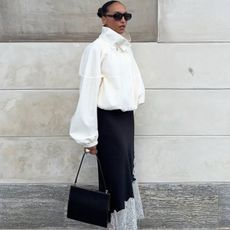 woman in a white jacket and black satin skirt