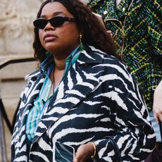 Gabriella Karefa-Johnson wearing a zebra print jacket and jeans at the Schiaparelli show during Paris Couture Week FW25. 