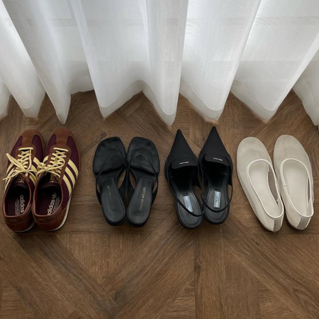 four pairs of shoes lined up in a hotel room